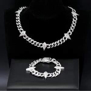 Detailweergave van zilveren Cubaanse schakelketting en armbandset met doornen hangers