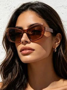 Detalle de gafas de sol cat-eye marrones de gran tamaño usadas por una modelo en exteriores
