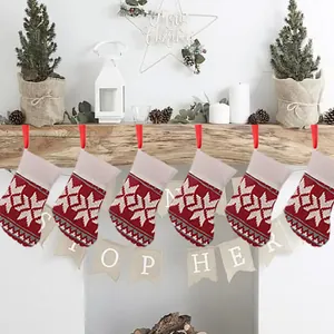Close-up of red and white knitted Christmas stockings with snowflake motifs on mantel