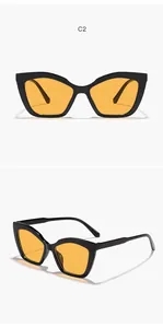 Detailed macro view of trendy cat-eye sunglasses with black frames and yellow lenses