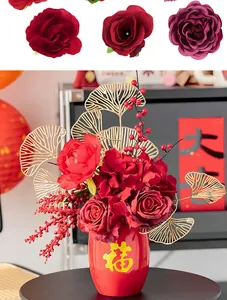 Close-up of red artificial silk rose heads and festive floral arrangement in a red vase