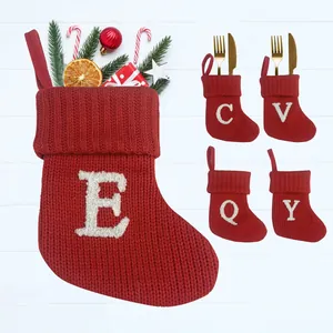 Rode gebreide kerstsokken met geborduurde letters voor decoratie