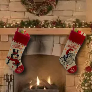 Dekorative Weihnachtsstrümpfe aus Sackleinen mit Weihnachtsmann am gemütlichen Kamin.