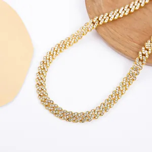 Détail macro d'un collier chaîne cubaine en or de 9 mm avec une rangée de strass brillants