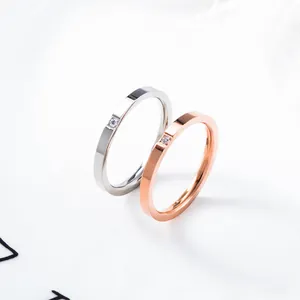Minimalistische titanium stalen koppelringen in zilver en roségoud met een enkele gezette diamant