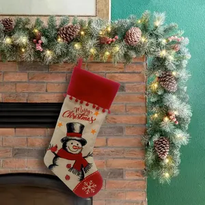 Festlicher Weihnachtsstrumpf aus Sackleinen mit Schneemann-Motiv am Kamin dekor.