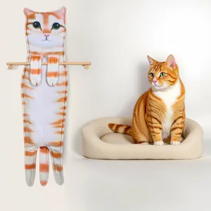 Detailed view of a realistic orange tabby cat hand towel hanging next to a real ginger cat