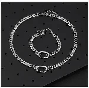 Gedetailleerd overzicht van een zilveren titanium stalen schakelketting en armband voor heren.