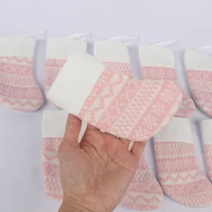 Close-up of pink knitted Christmas stocking with zigzag patterns for holiday gifts.