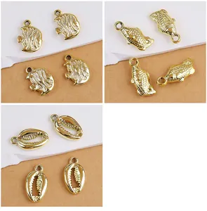 Detail view of golden CCB sea shell and fish charms for DIY jewelry making projects