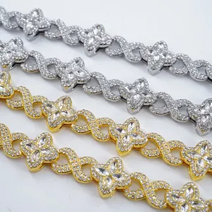Macro view of gold and silver iced out necklaces featuring clover and figure-8 link designs
