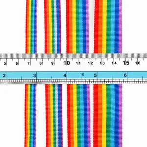 Detailed shot of multi-width rainbow polyester ribbons with a ruler for scale