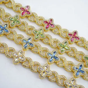 Close-up detail of gold infinity link necklace with vibrant colorful clover crystals