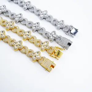 Close-up detail of four leaf clover and infinity symbol Cuban link necklaces in gold and silver