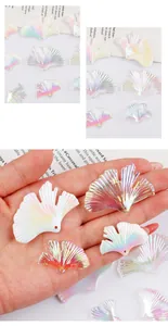 Detail view of iridescent ginkgo leaf charms featuring pendant holes for DIY jewelry craft