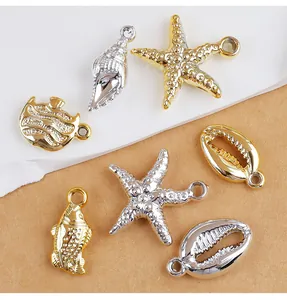 Close-up view of gold and silver starfish and shell CCB pendants for DIY jewelry making.