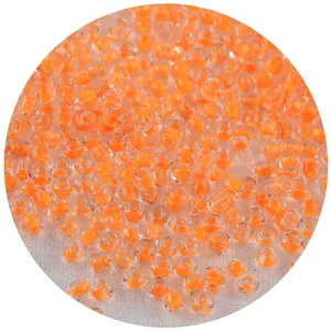 Detalle macro de cuentas de vidrio con núcleo naranja para la creación de joyas DIY.