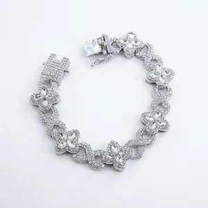 Detail of silver four-leaf clover and infinity link bracelet with iced-out rhinestones