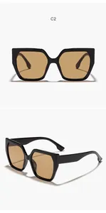 Close-up detail of square cat-eye sunglasses featuring black frame and amber lenses