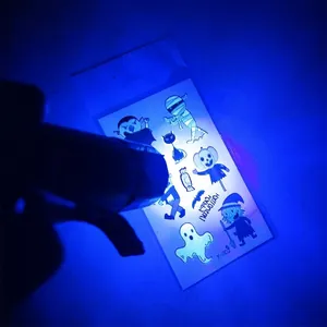 Gros plan d'une lampe UV éclairant des tatouages d'Halloween fluorescents la nuit