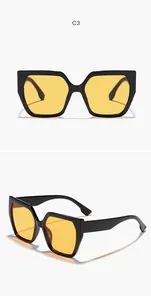 Front and side detail views of oversized black cat-eye sunglasses with yellow lenses.