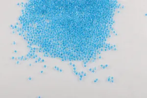 Primer plano de pequeñas cuentas de vidrio azul vibrante con núcleo teñido sobre tela