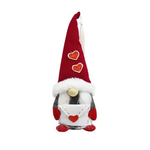 Detailed view of red holiday gnome doll holding a white heart envelope