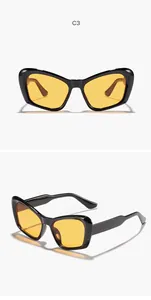 Vista detallada de gafas de sol cat-eye de gran tamaño con lentes amarillas y montura negra