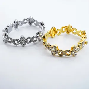 Detailed view of gold and silver four-leaf clover infinity link bracelets with crystals.