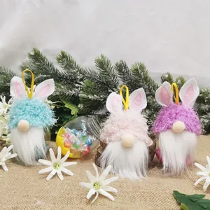 Detailansicht von drei bunten Osterhasen-Zwergen und einem Bonbonglas auf Sackleinen