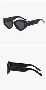Detailopname van een zwarte ovale cat-eye zonnebril met goudkleurige sterrenstuds.