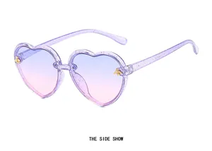 Side view of heart-shaped glitter kids sunglasses with golden bee accents