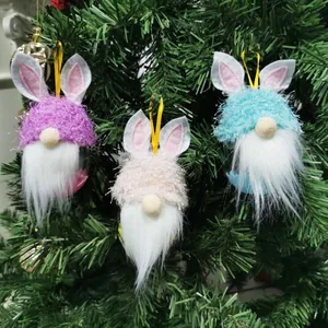 Nahaufnahme von bunten Plüsch Osterhase Gnom Ornamenten an einem grünen Baum