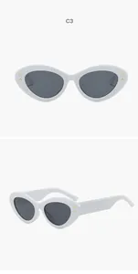 Close-up van witte cat-eye zonnebril met goudkleurige stervormige klinknagels op de hoeken