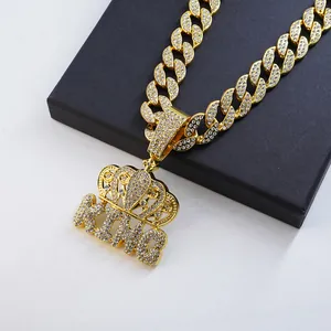 Close-up of iced out crown KING pendant on a golden hip hop Cuban link chain necklace.