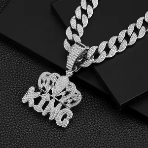 Detailed macro view of iced out silver crown KING pendant with rhinestones on Cuban link chain