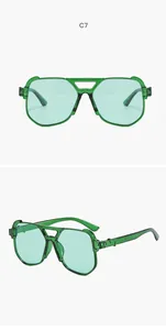 Macro detail of oversized green aviator sunglasses featuring a unique double bridge frame