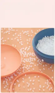 Close-up of safe, non-toxic white beads and colorful plastic bowls for DIY crafts