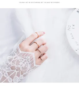 Nahaufnahme von minimalistischen, dünnen Ringen in Roségold an einer Hand.