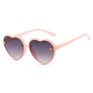 Children's pink heart-shaped sunglasses with cute gold bee accents and gradient lenses
