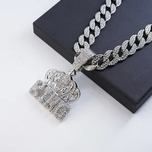 Exquisite detail of iced out silver crown KING pendant on a thick Cuban link chain