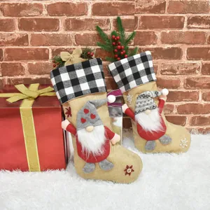 Detailweergave van rustieke jute kerstsokken met schattige kabouterfiguurtjes erop.