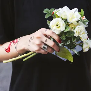 Verstellbarer Feder- und Pfeilring aus Silber, präsentiert mit einem Blumenstrauß.