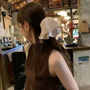 Detaillierte Seitenansicht einer eleganten Haarklammer aus cremefarbenem Satin mit Perlen