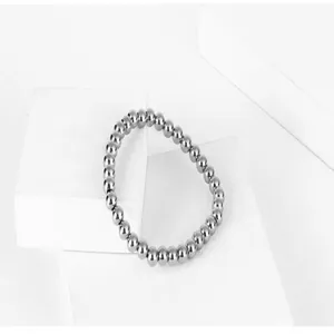 Macro view of polished silver titanium steel beads on minimalist jewelry display blocks