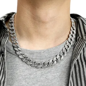 Detailed view of an iced out silver Cuban link necklace worn on a male model neck
