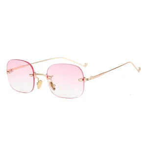 Occhiali da sole ovali senza montatura con lenti sfumate rosa e montatura in metallo dorato.