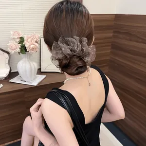 Back view of a large French floral pleated banana clip on an elegant hair bun accessory