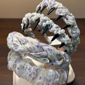 Detail view of stylish purple floral pleated and pearl-embellished headbands for women