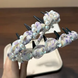 Macro detail of a purple floral pleated headband decorated with elegant pearls and crystals